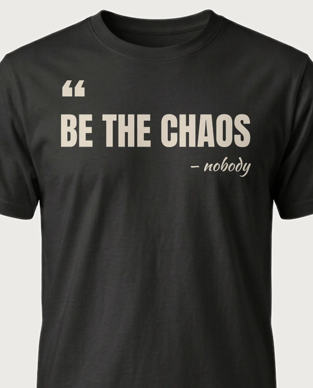 'Be the chaos' — The Quote on a black tee