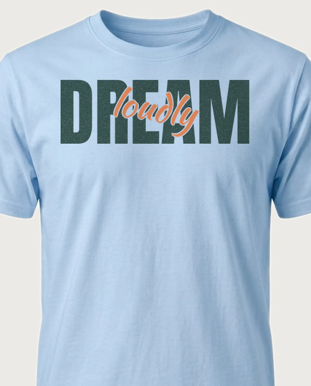 dream LOUDLY — Script Overlay on a light blue tee